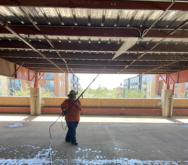 Pressure washing parking garage overhead beams